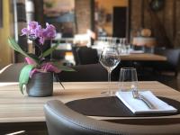 una mesa con una servilleta y dos vasos y un jarrón de flores en L'auberge fleurie, en Heilly