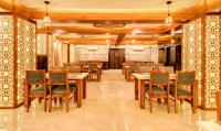 Un comedor con mesas y sillas de madera. en Opulence Inn - 500 Meters From Railway Station, en Udaipur