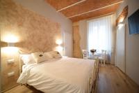 Un dormitorio con una cama blanca y una mesa. en Casa Martimbola Self Check-in, en Arezzo