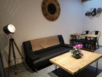 a living room with a black couch and a table at Cathy et eric in Beaurevoir