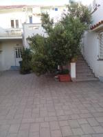 a building with a staircase and trees in a courtyard at Apartment Tičić in Povljana