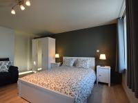 a bedroom with a bed and two tables and two lamps at Modern Holiday Home in Florenville with Garden in Chassepierre
