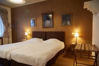 コルトレイクにあるFocus Hotelのベッドルーム1室(ベッド1台、テーブル2台、壁に2枚の写真付)