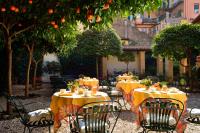 an outdoor restaurant with tables and chairs with oranges at Hotel Santa Maria in Rome