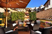 an outdoor patio with chairs and an umbrella at Hotel Santa Maria in Rome