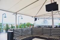 Un banco debajo de una carpa blanca con un televisor de pantalla plana. en Kapal Garden Hotel at Rekreasi Sengkaling, en Malang