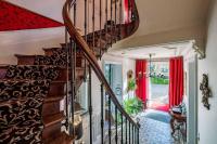 a spiral staircase in a home with red curtains at Le Pavillon des Lys - Hôtel Particulier in Amboise