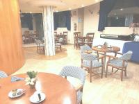 un restaurante con mesas de madera, sillas, mesas y una mesa en Hotel Nueva Plaza, en Maliaño