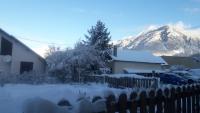 a snow covered yard with a house and a mountain at Le Bacchu Ber in Briançon