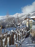 a tree covered in snow next to a fence at Le Bacchu Ber in Briançon