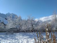 a park covered in snow with benches and trees at Le Bacchu Ber in Briançon