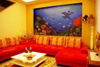 a living room with red couches and a large painting at Hai Yang Feng Qing Homestay in Hualien City