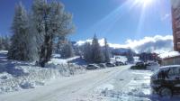 a road covered in snow with cars parked on it at Appartement d&#39;une chambre avec vue sur la ville balcon et wifi a Chamrousse in Chamrousse