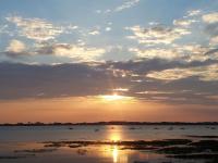 a sunset over a body of water with boats at Maison de 3 chambres avec vue sur la mer jardin clos et wifi a Regneville sur Mer a 2 km de la plage in Regnéville-sur-Mer