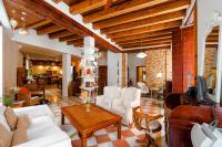 a living room with white furniture and wooden ceilings at Hotel Argantonio in Cádiz