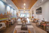 a restaurant with tables and chairs and a painting on the wall at Le's Cham Hotel in Nha Trang