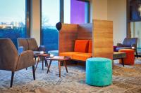 Un vestíbulo con un sofá, sillas y mesas. en Emils Hotel, en Pirmasens