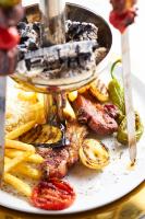 a plate of food with meat and french fries at Ricosta Hotel in Rize