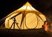 a woman sitting in a chair in front of a tent at Glamping at Camping La Source in Saint-Pierre-dʼArgençon