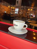 a cup of coffee sitting on a counter in a restaurant at Piano Hotel in İzmir