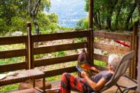 a man sitting in a chair reading a book at Camping Mille Étoiles in Labastide-de-Virac