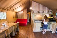 a little girl standing in the kitchen of a trailer at Camping Mille Étoiles in Labastide-de-Virac