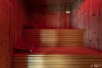 an empty sauna with a bench in a red room at Le Loft in Stoumont