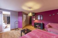 a room with purple walls and a bed and a desk at Le Loft in Stoumont