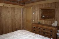 a bedroom with a bed and a wooden wall at Chalet les SORBIERS, en rondins, classé 4****étoiles in Bolquere Pyrenees 2000