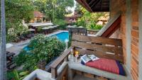 a balcony with a bench and a swimming pool at Yaang Come Village Hotel in Chiang Mai