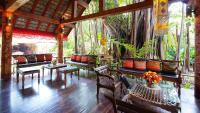 a restaurant with tables and chairs and a tree at Yaang Come Village Hotel in Chiang Mai