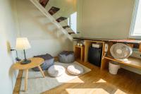 a living room with a staircase with a table and a fan at SSS Life Hotel in Tainan