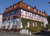 a red and white building with ivy at Ferienwohnung Wacker, Apartments und Zimmer in Züschen