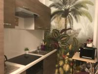 a kitchen with a sink and a palm tree on the wall at Les Coulisses de l&#39;HORLOGE - WIFI - 50 m Palais des Papes in Avignon