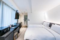 a hotel room with two beds and a tv at RF Hotel - Zhongxiao in Taipei