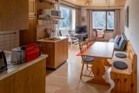 Una cocina y una sala con una mesa y un comedor. en Panorama at Haus Waldheim Nr. 11, en Grächen