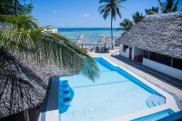 Una piscina junto a un resort con vista al mar. en Sheratton Beach Villagio, en Mombasa