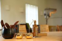 a table with glasses and a bottle and a plant at B&amp;B Leonie in Alveringem