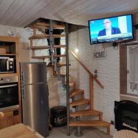 a room with a staircase and a tv on a wall at Chez Isa in Yport