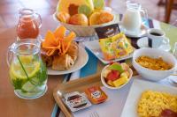 a table topped with plates of breakfast foods and drinks at Karibea Squash Hôtel in Fort-de-France