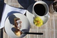 einen Teller mit einem Stück Kuchen und einer Tasse Kaffee in der Unterkunft Posada Hostel La Piedra Mística in La Pedrera