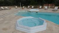 a swimming pool with a tub in the middle at Bastide De Mazan in Riez