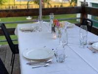 a table with white plates and glasses and flowers on it at Haus 26 Weißbriach in Weissbriach