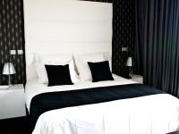 a bedroom with a large bed with black and white pillows at Lutecia Smart Design Hotel in Lisbon