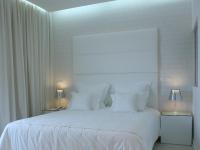 a white bedroom with a large white bed with white pillows at Lutecia Smart Design Hotel in Lisbon