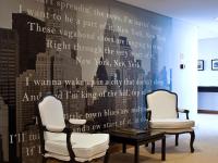a room with two chairs and a table and a wall with words at Lutecia Smart Design Hotel in Lisbon