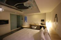 a bedroom with a bed and a bathroom with a sink at Hotel Papa Whale-Kaohsiung Formosa Boulevard in Kaohsiung