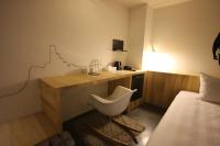 a hotel room with a desk and a bed and a chair at Hotel Papa Whale-Kaohsiung Formosa Boulevard in Kaohsiung
