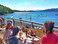 un gruppo di persone sedute a un tavolo sulla spiaggia di Loch Insh Chalets and Apartments a Kincraig