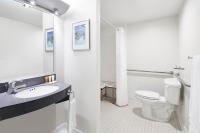 ein Badezimmer mit Toilette, Waschbecken und Spiegel in der Unterkunft Club Quarters Hotel Embarcadero, San Francisco in San Francisco